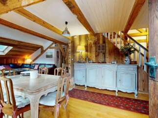 Experience rustic charm in this mountain retreat, featuring exposed wooden beams and a cozy living area with a fireplace.