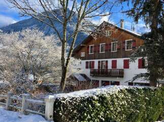Experience the charm of this winter wonderland property, nestled against a backdrop of snow-capped mountains.