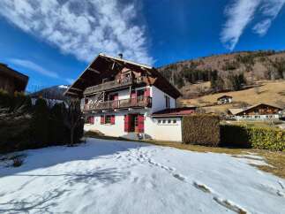 Experience the charm of this traditional alpine chalet, nestled against a backdrop of rolling hills and snow-dusted mountains.
