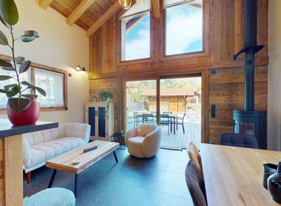 Experience the ultimate alpine retreat in this stunning living space, featuring a vaulted wooden ceiling and a cozy fireplace.