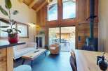 Experience the ultimate alpine retreat in this stunning living space, featuring a vaulted wooden ceiling and a cozy fireplace.