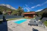 Experience ultimate relaxation in this stunning property featuring a pristine swimming pool and comfortable lounge chairs, perfect for soaking up the sun.