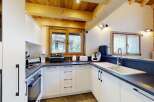 Experience modern comfort in this beautifully appointed kitchen, featuring sleek white cabinetry and a dark countertop.