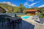 Enjoy a luxurious mountain retreat with this stunning property featuring a private swimming pool and a spacious outdoor dining area perfect for al fresco meals.