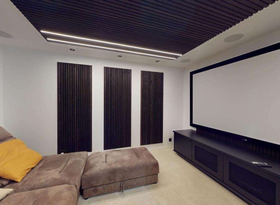 Experience cinematic bliss in this dedicated home theater, featuring a massive projector screen and plush, comfortable seating.