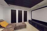 Experience cinematic bliss in this dedicated home theater, featuring a massive projector screen and plush, comfortable seating.