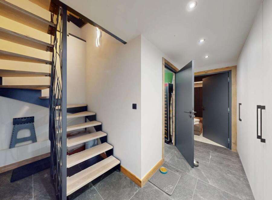 Discover modern living with this stunning staircase, featuring sleek wooden treads and a unique metal railing that adds an artistic touch.