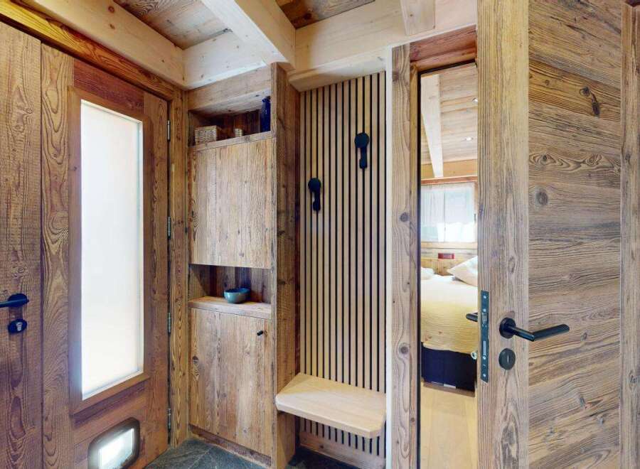 Step into a charming mountain retreat featuring rustic wooden interiors and a cozy entryway.
