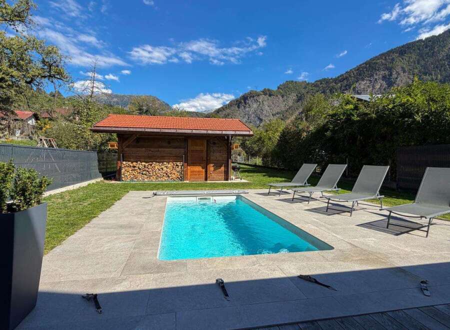 Escape to this stunning mountain retreat featuring a private swimming pool and ample lounge chairs for ultimate relaxation.