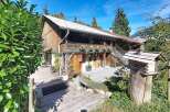 Experience rustic charm in this traditional wooden chalet, nestled amidst lush greenery and offering a picturesque mountain view.