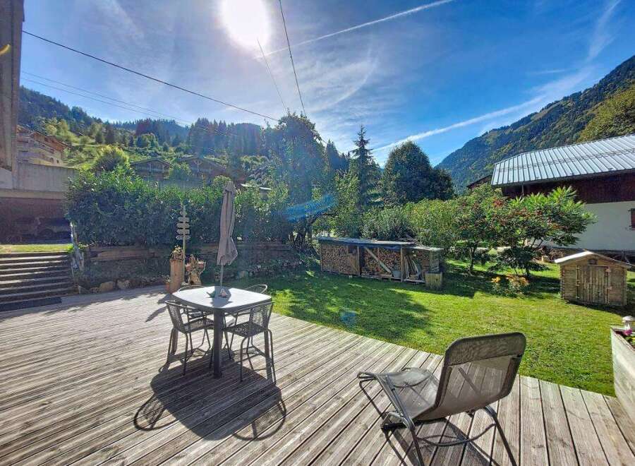 Enjoy the stunning mountain views from this charming property's spacious wooden deck, perfect for outdoor dining or relaxing.