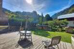 Enjoy the stunning mountain views from this charming property's spacious wooden deck, perfect for outdoor dining or relaxing.