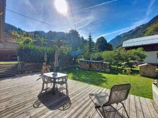 Enjoy the stunning mountain views from this charming property's spacious wooden deck, perfect for outdoor dining or relaxing.