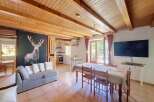 Experience rustic charm in this open-plan living and dining area, featuring a striking stag mural and exposed wooden beams.