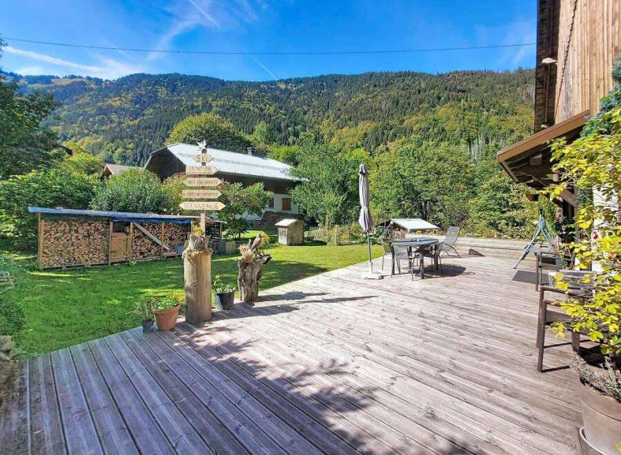Experience the charm of this mountain retreat, featuring a spacious wooden deck perfect for outdoor dining and relaxation.
