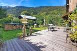 Experience the charm of this mountain retreat, featuring a spacious wooden deck perfect for outdoor dining and relaxation.