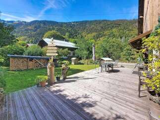 Experience the charm of this mountain retreat, featuring a spacious wooden deck perfect for outdoor dining and relaxation.
