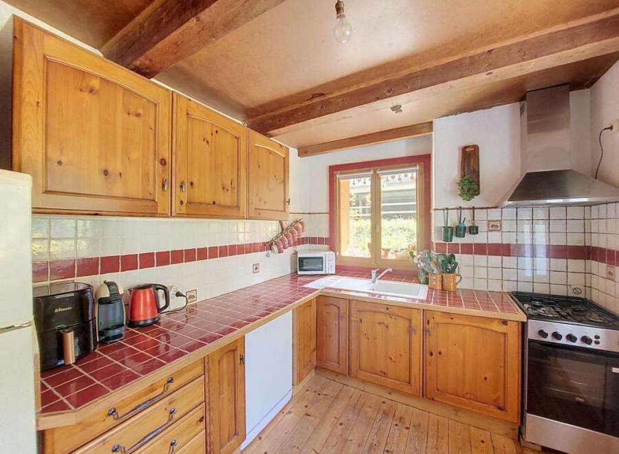 This charming kitchen features warm wooden cabinetry and a rustic tiled backsplash, creating a cozy and inviting atmosphere.