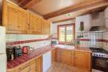 This charming kitchen features warm wooden cabinetry and a rustic tiled backsplash, creating a cozy and inviting atmosphere.
