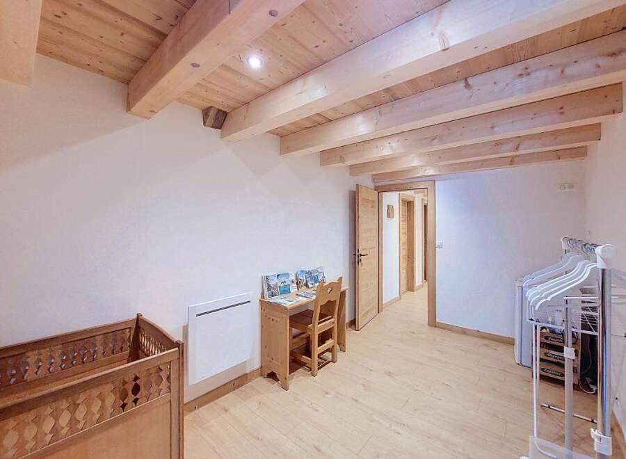Discover this charming room featuring a rustic wooden crib and a quaint desk area, perfect for a child's space.