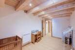 Discover this charming room featuring a rustic wooden crib and a quaint desk area, perfect for a child's space.