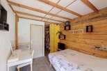 Discover this charming bedroom featuring a cozy bed with a nature-inspired duvet and a functional white desk area, perfect for work or study.