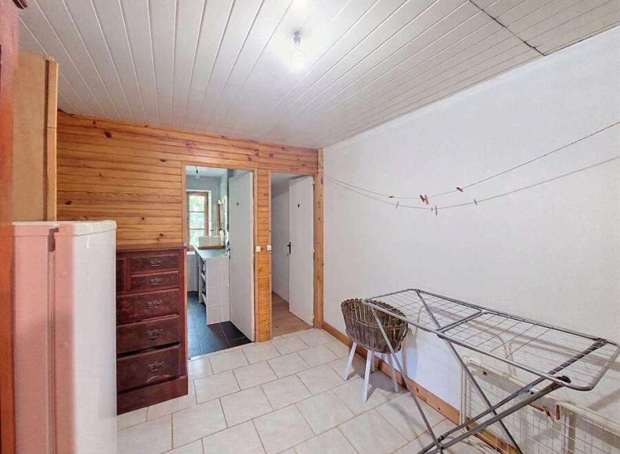 This charming room features a rustic wooden accent wall and a practical white refrigerator.