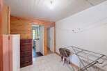 This charming room features a rustic wooden accent wall and a practical white refrigerator.