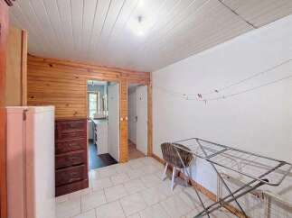 This charming room features a rustic wooden accent wall and a practical white refrigerator.