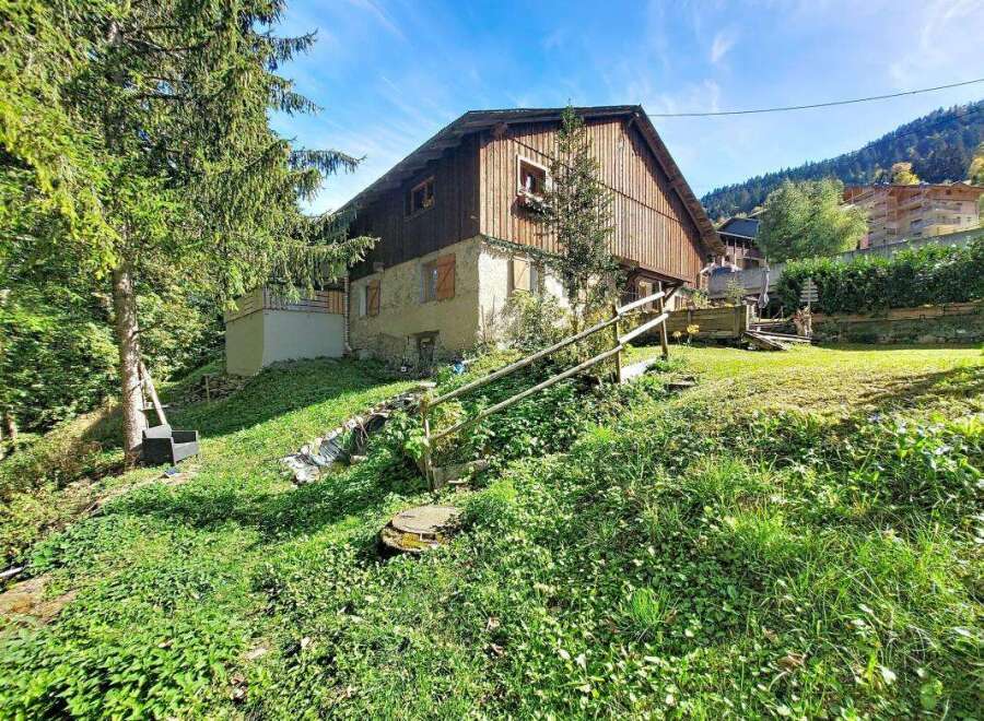 Nestled amidst lush greenery, this charming property offers a serene escape with its rustic wooden facade and stone accents.