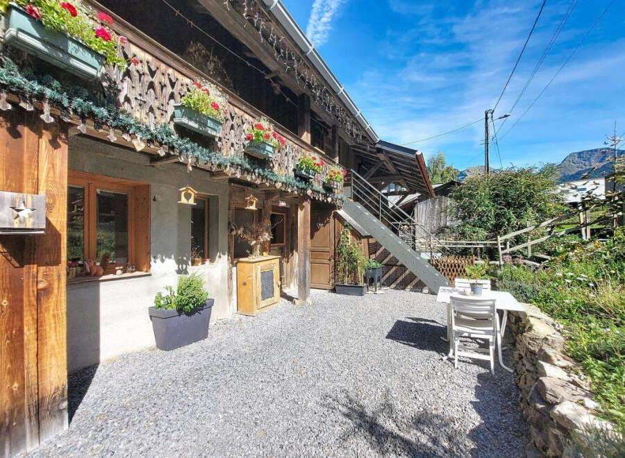 Charming alpine property featuring a rustic wooden facade adorned with flower boxes and intricate carvings.