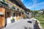 Charming alpine property featuring a rustic wooden facade adorned with flower boxes and intricate carvings.