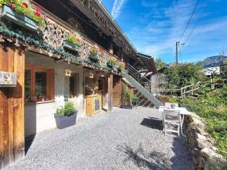 Charming alpine property featuring a rustic wooden facade adorned with flower boxes and intricate carvings.