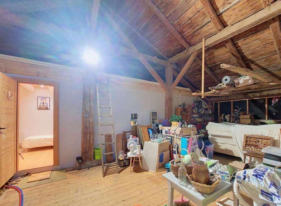 Discover the potential of this spacious attic, featuring exposed wooden beams and a charming rustic aesthetic.