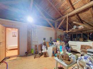 Discover the potential of this spacious attic, featuring exposed wooden beams and a charming rustic aesthetic.