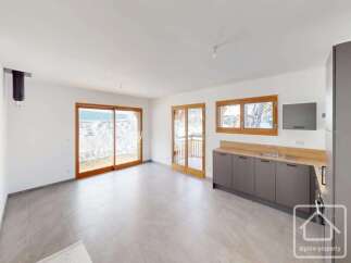 Experience modern living in this spacious open-plan room featuring a sleek grey kitchen with ample counter space and integrated appliances.