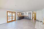 Experience modern living in this spacious open-plan apartment, featuring a sleek, contemporary kitchen with ample counter space and integrated appliances.