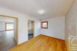 Experience modern living in this beautifully appointed room featuring warm wooden floors and a striking wood-paneled accent wall.