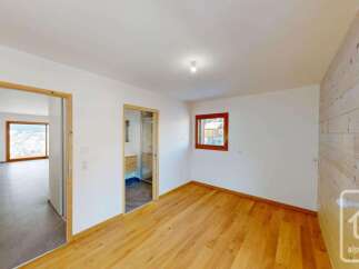 Experience modern living in this beautifully appointed room featuring warm wooden floors and a striking wood-paneled accent wall.