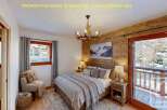 Experience cozy mountain living in this charming bedroom, featuring a rustic wooden accent wall and a plush, inviting bed.