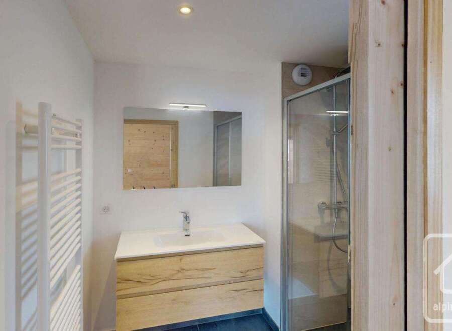 This modern bathroom features a sleek vanity with ample storage and a clean white countertop.