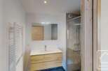 This modern bathroom features a sleek vanity with ample storage and a clean white countertop.