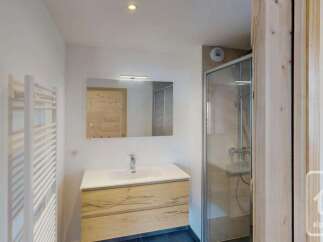 This modern bathroom features a sleek vanity with ample storage and a clean white countertop.