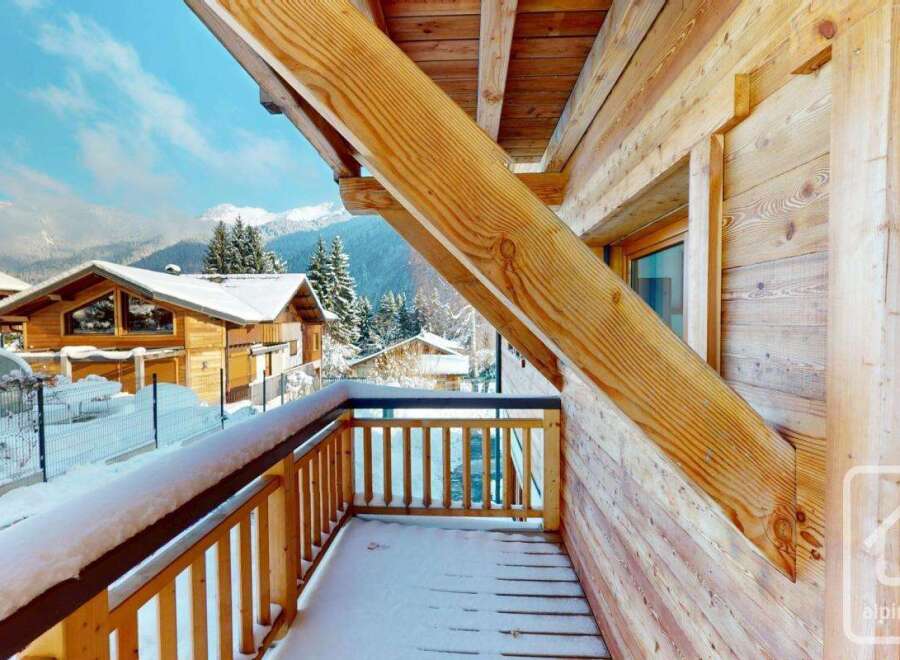 Experience the charm of a winter wonderland from this charming wooden balcony.