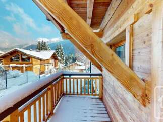 Experience the charm of a winter wonderland from this charming wooden balcony.