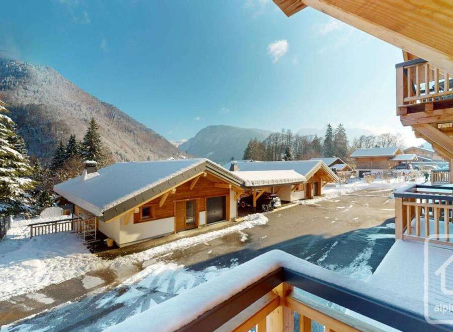 Experience the charm of a winter wonderland with these stunning wooden chalets nestled in a snowy mountain landscape.