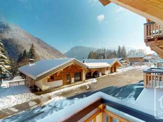 Experience the charm of a winter wonderland with these stunning wooden chalets nestled in a snowy mountain landscape.
