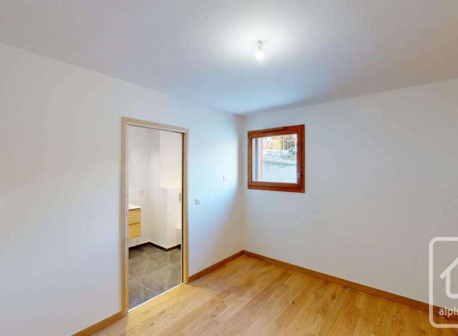 This bright and airy room features a modern interior with clean white walls and a beautiful wooden floor.