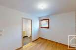 This bright and airy room features a modern interior with clean white walls and a beautiful wooden floor.