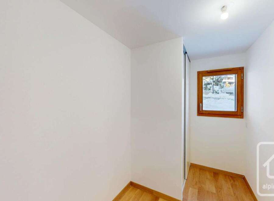 This bright and airy room features a large window offering scenic views of the snowy landscape outside.